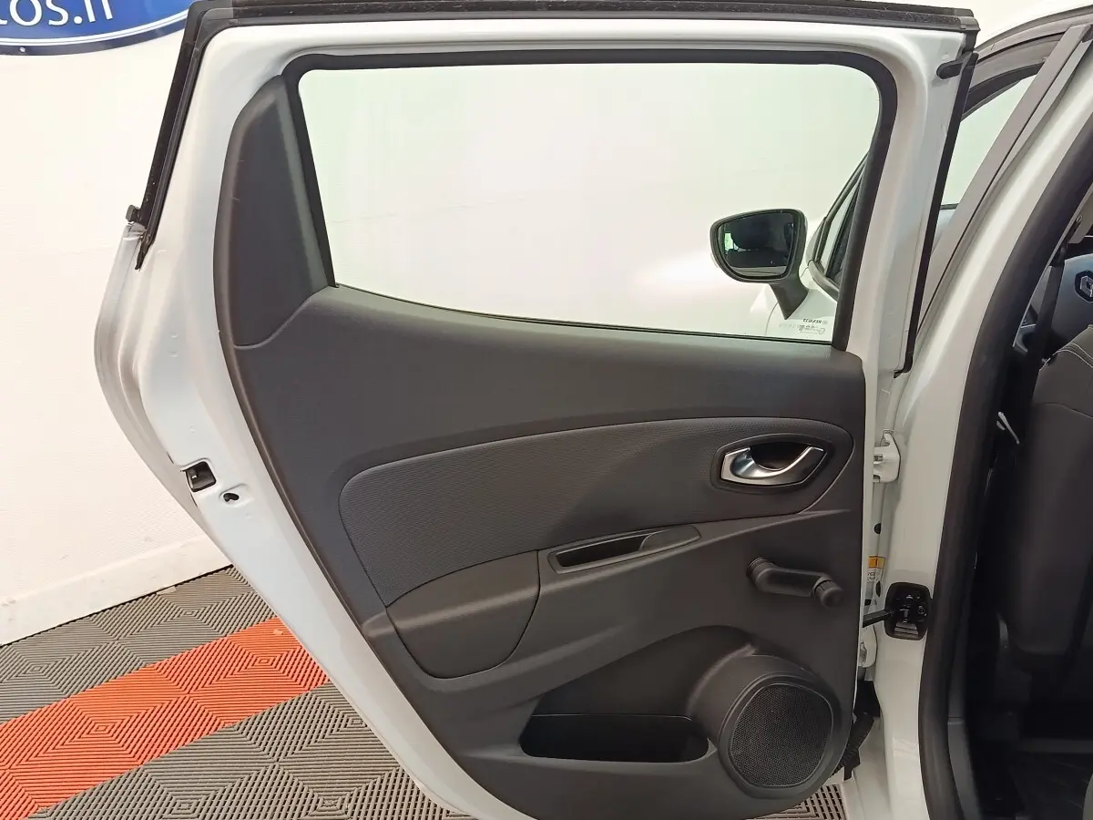 Vue intérieure de la porte arrière droite blanche d’une Renault Clio 2018 avec poignée et manivelle de vitre.