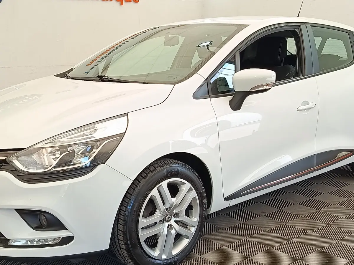 Renault Clio Business dCi 75 blanc vue 3/4 avant droit, avec jantes alliage et rétroviseur blanc intégré clignotant.