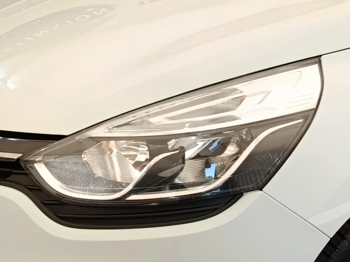 Gros plan sur le phare avant droit blanc d’une Renault Clio Business dCi 75 de 2018.