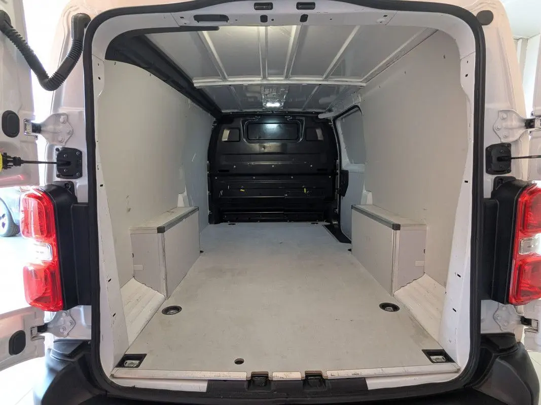 Vue arrière intérieure du fourgon FIAT Scudo XL blanc 2025, montrant l'espace de chargement vide et les portes ouvertes à 180 degrés.