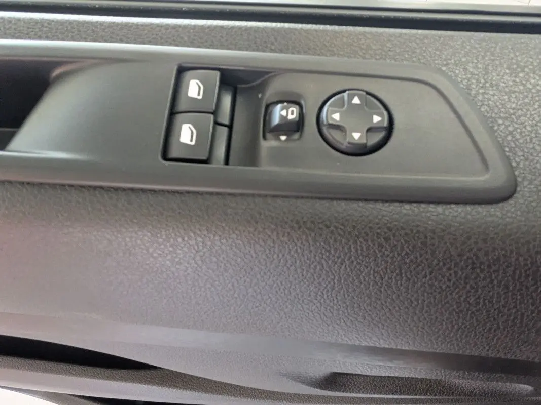 Détail des commandes de réglage des vitres et des rétroviseurs sur la porte intérieure côté conducteur du Fiat Scudo Fourgon blanc.