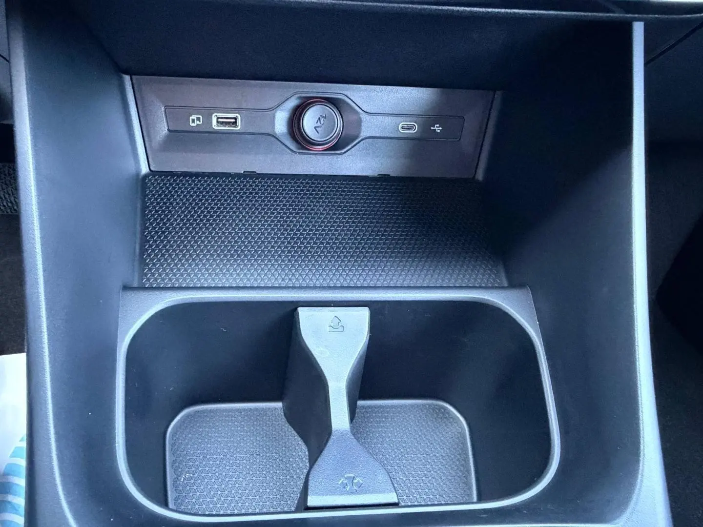 Gros plan sur la console centrale noire du MG3 1.5 Hybrid+ 195ch Luxury avec prises USB et prise 12V visibles.