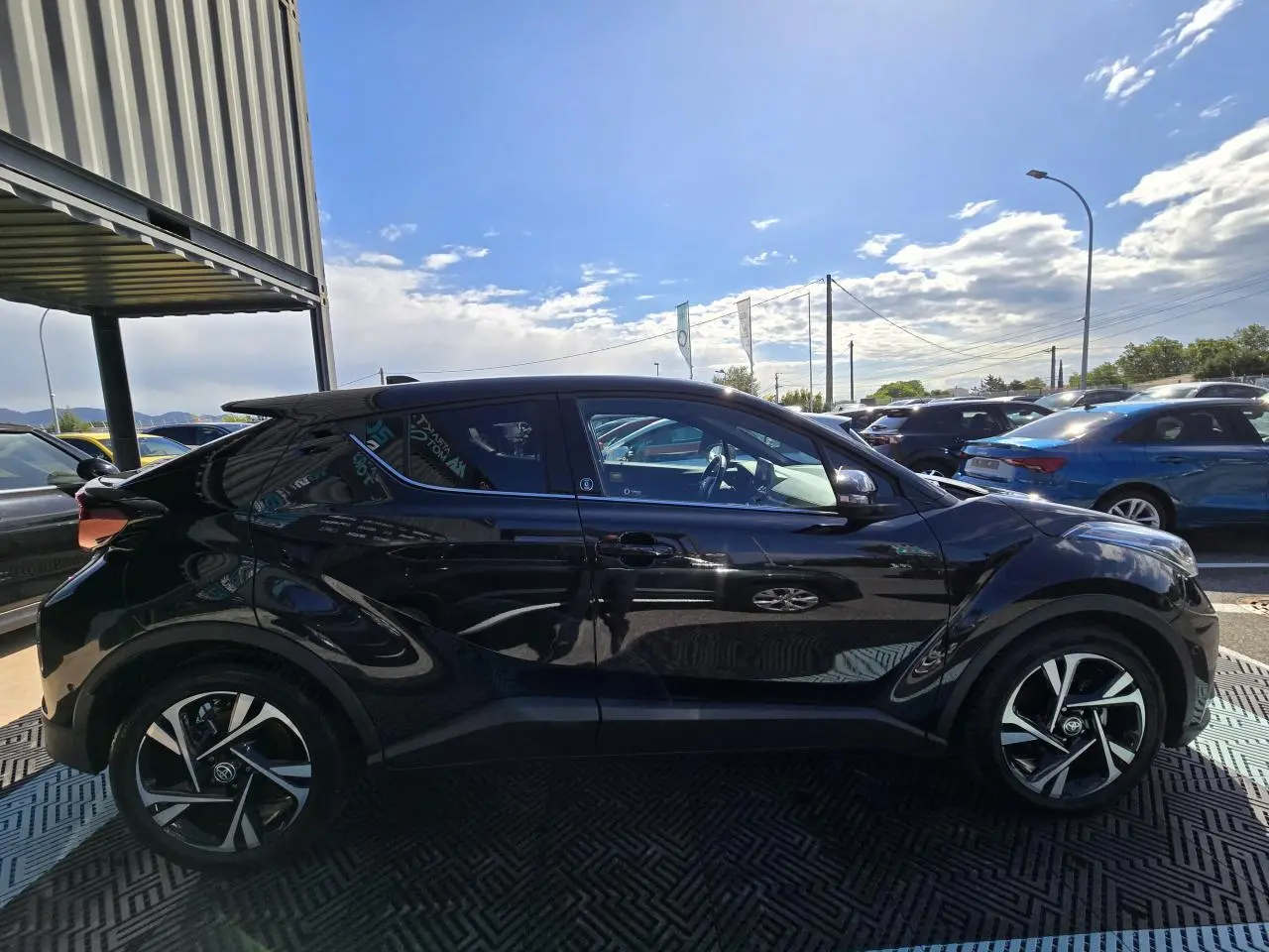 Profil côté gauche du Toyota C-HR noir métal 2023 avec jantes alliage et lignes sculptées distinctives.