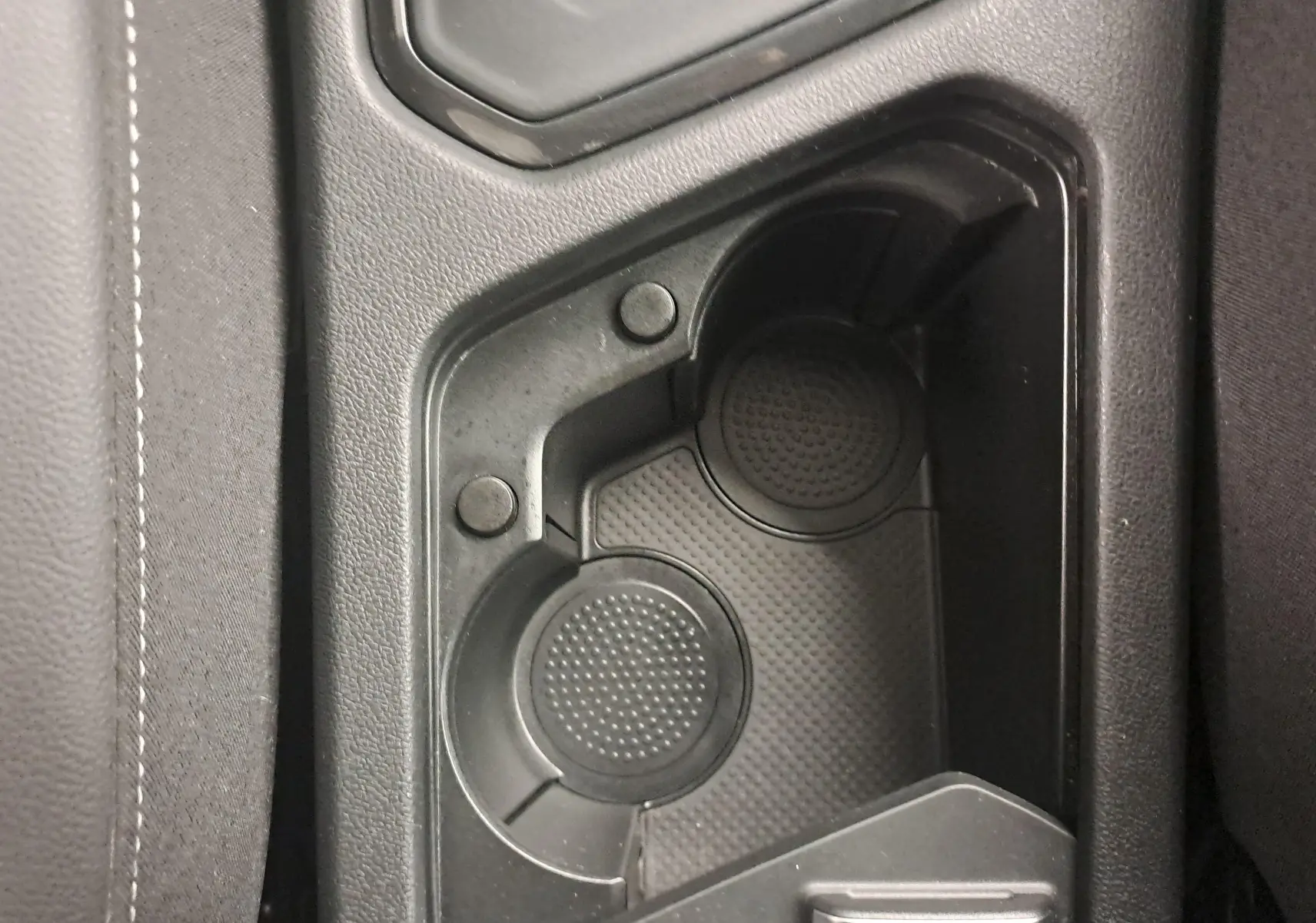 Gros plan sur les porte-gobelets noirs au centre de la console du Volkswagen Tiguan 1.4 eHybrid R-Line blanc pur 2023.