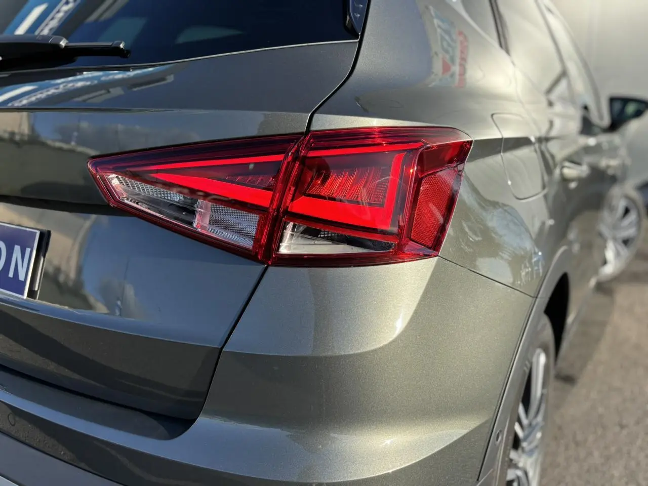 Gros plan sur le feu arrière droit d'un SEAT Arona 2025 gris Cliff avec peinture métallisée et jante alliage visible.