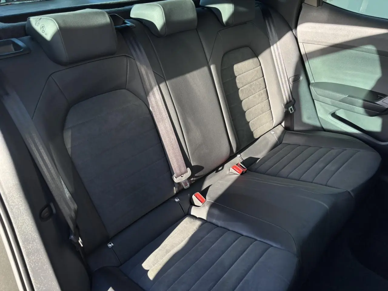 Vue intérieure du siège arrière en cuir noir et tissu gris du SEAT ARONA TSI 115 Xpérience 2025, côté droit.