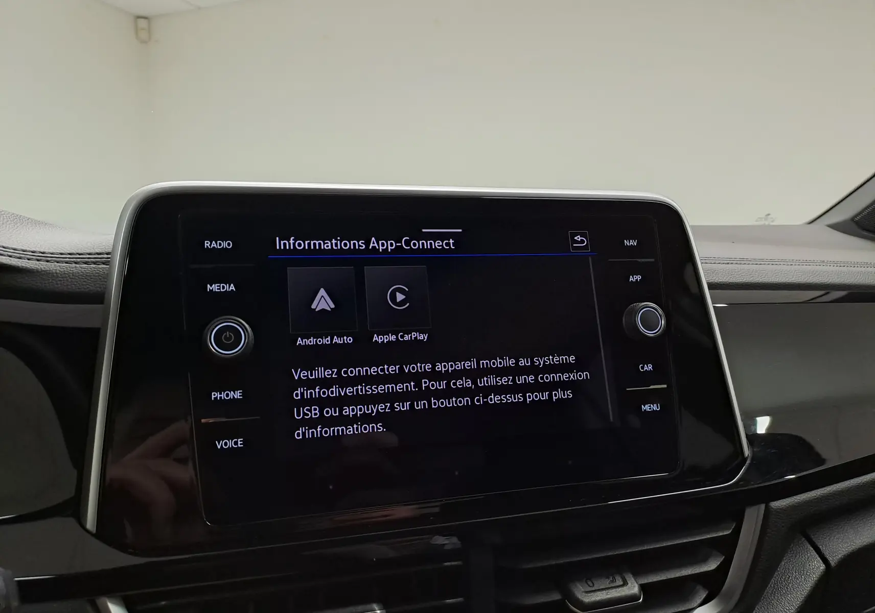 Écran tactile central du Volkswagen T-Roc 2025 affichant les options Android Auto et Apple CarPlay dans un intérieur noir.