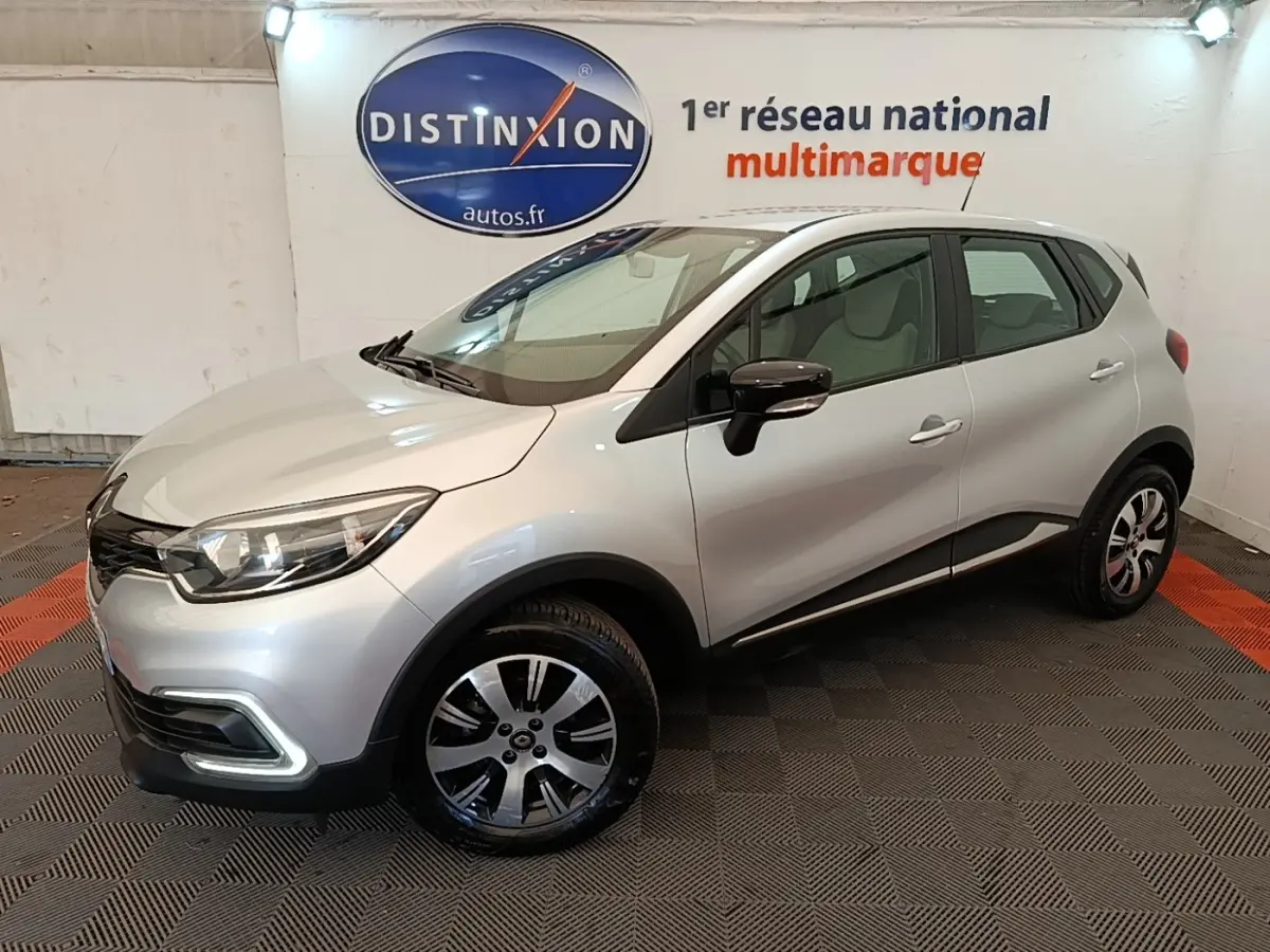 Renault Captur Zen TCe 90 gris clair en 3/4 avant droit, avec jantes alliage et rétroviseurs noirs brillants.