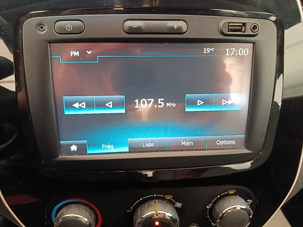 Gros plan sur l’écran tactile central et les commandes de climatisation du Renault Captur Zen TCe 90 gris clair.