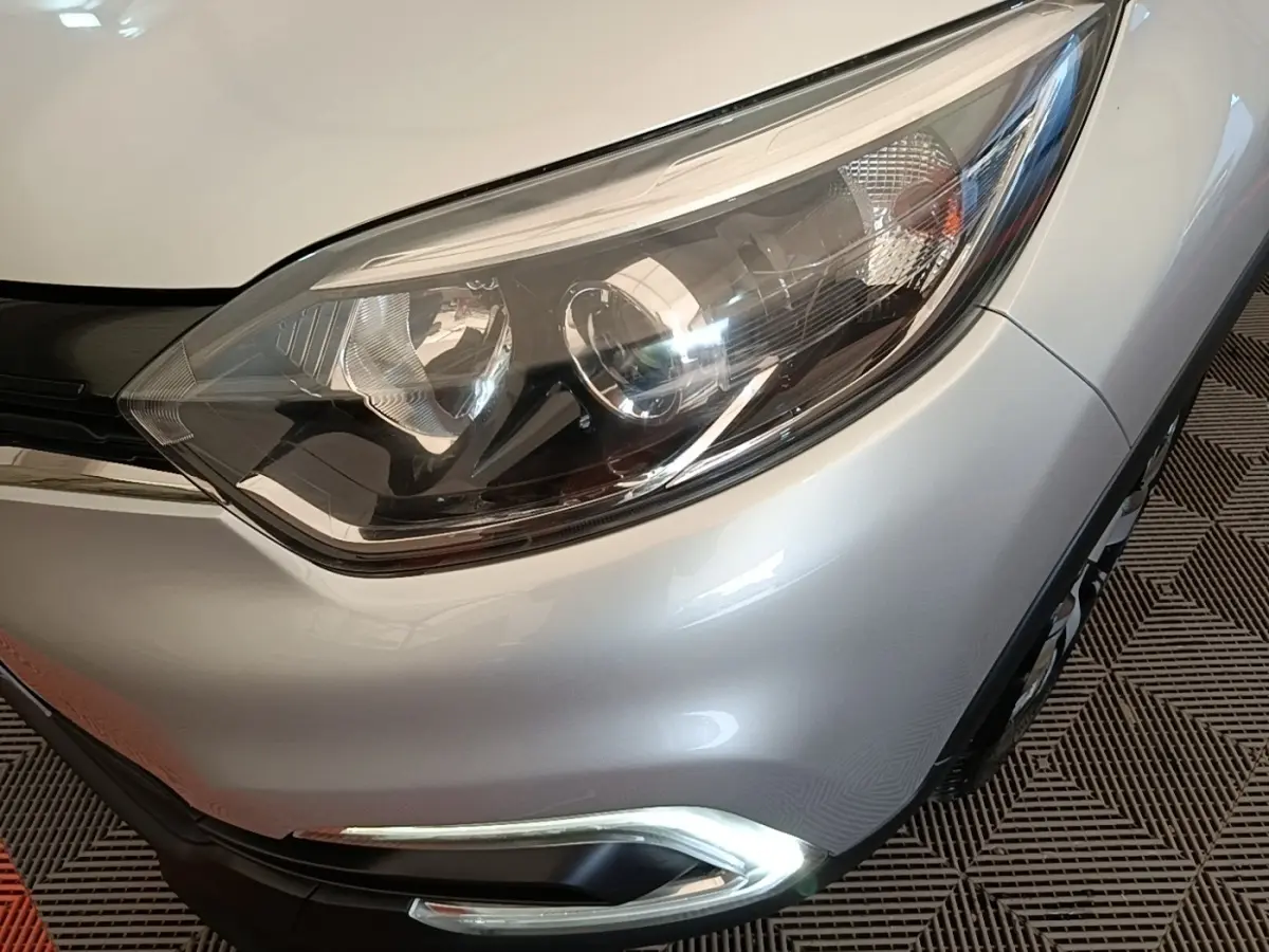 Gros plan sur le phare avant droit gris clair du Renault Captur Zen TCe 90 de 2018 avec feu de jour LED allumé.