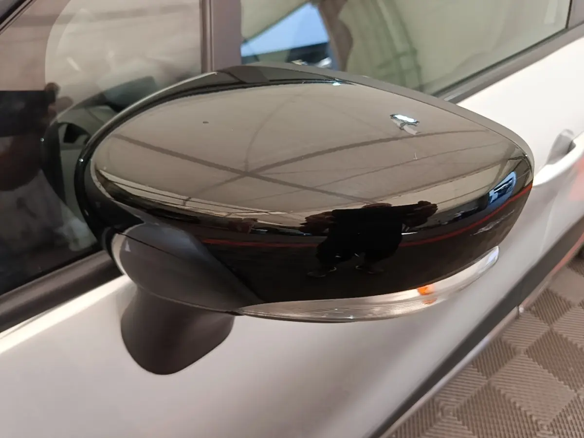 Rétroviseur droit noir brillant du Renault Captur gris clair, vue rapprochée sur la portière côté droit.