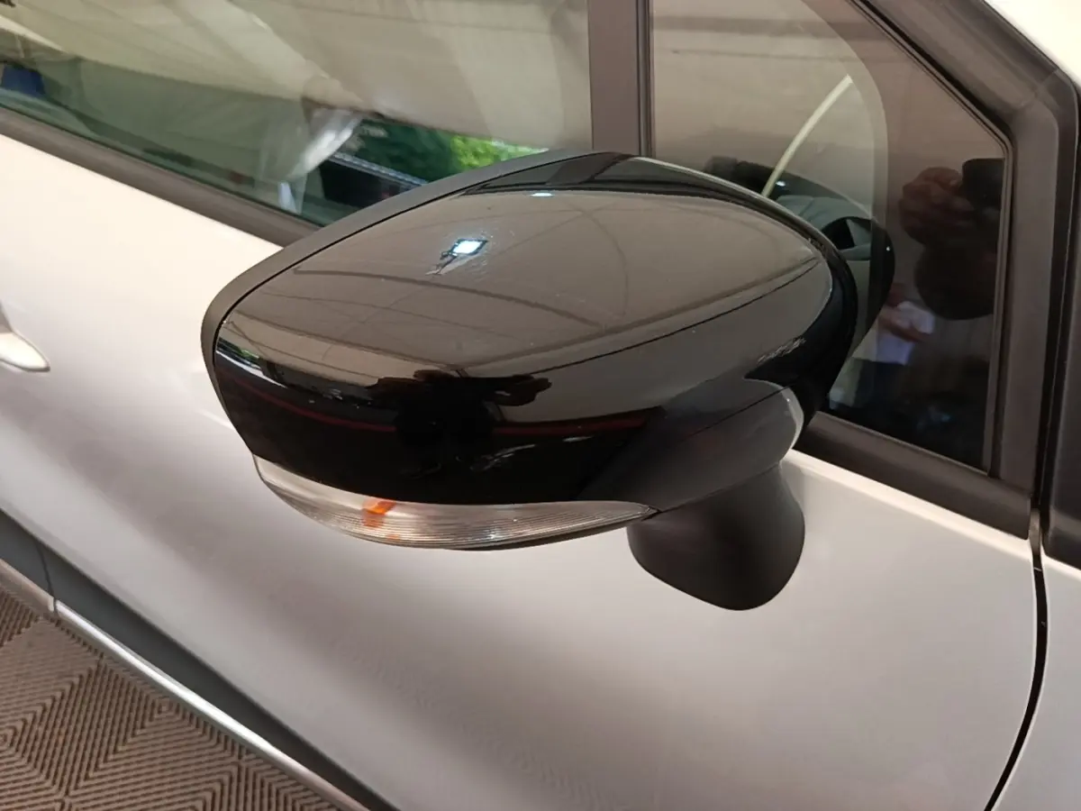 Rétroviseur noir brillant côté gauche du Renault Captur gris clair 2018, avec clignotant intégré visible.