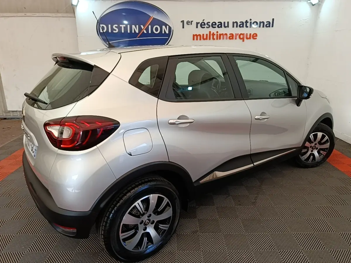 Vue 3/4 arrière droite d'un Renault Captur gris clair 2018 avec feux LED et jantes alliage.