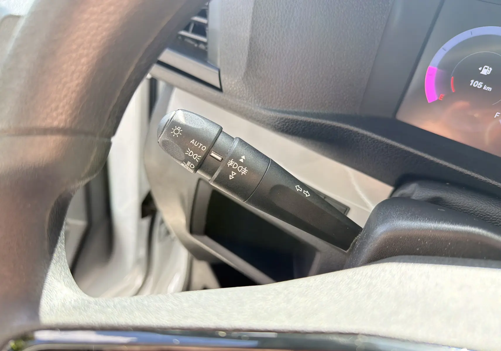 Gros plan sur la manette de commande d’éclairage et clignotants du FIAT Scudo Fourgon blanc, tableau de bord partiellement visible.