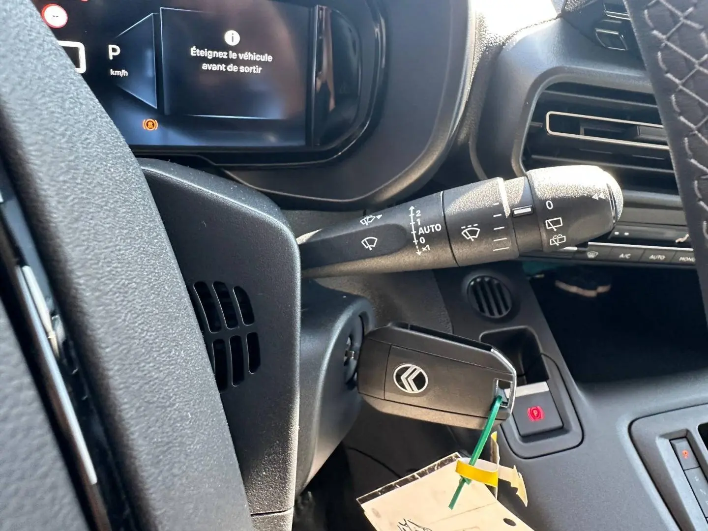 Gros plan sur le tableau de bord noir du Citroën Berlingo 2026 avec clé insérée et affichage digital indiquant d'éteindre le véhicule.