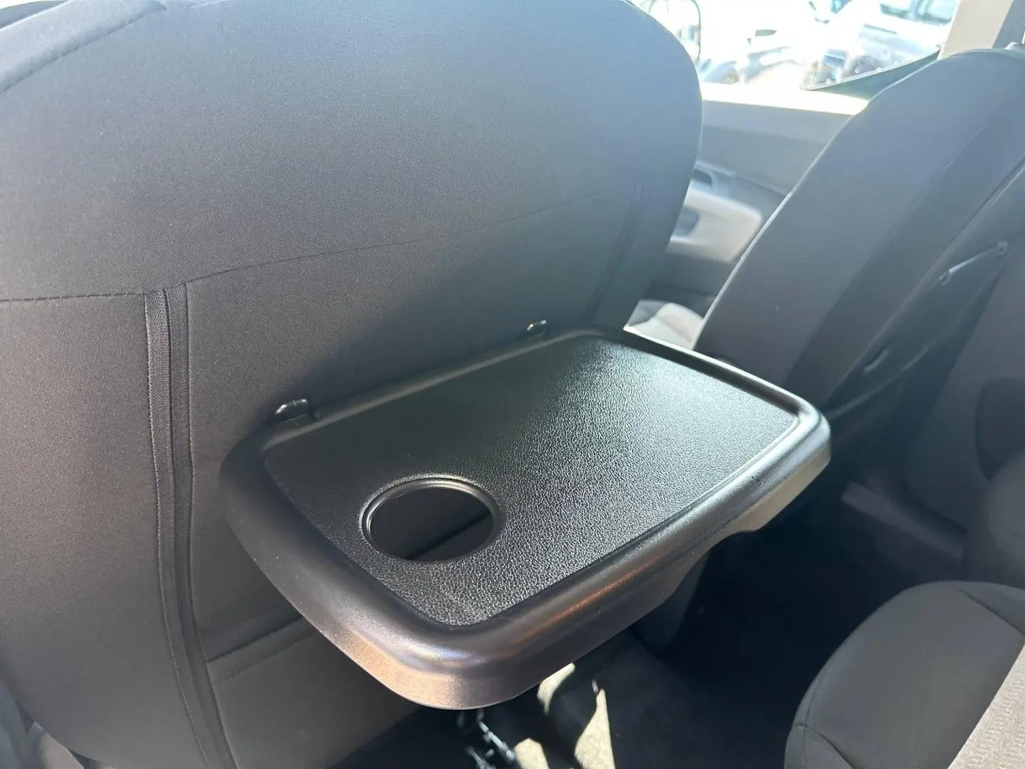 Tablette arrière dépliée avec porte-gobelet sur siège avant, vue intérieure du Citroën Berlingo Kiama Blue.