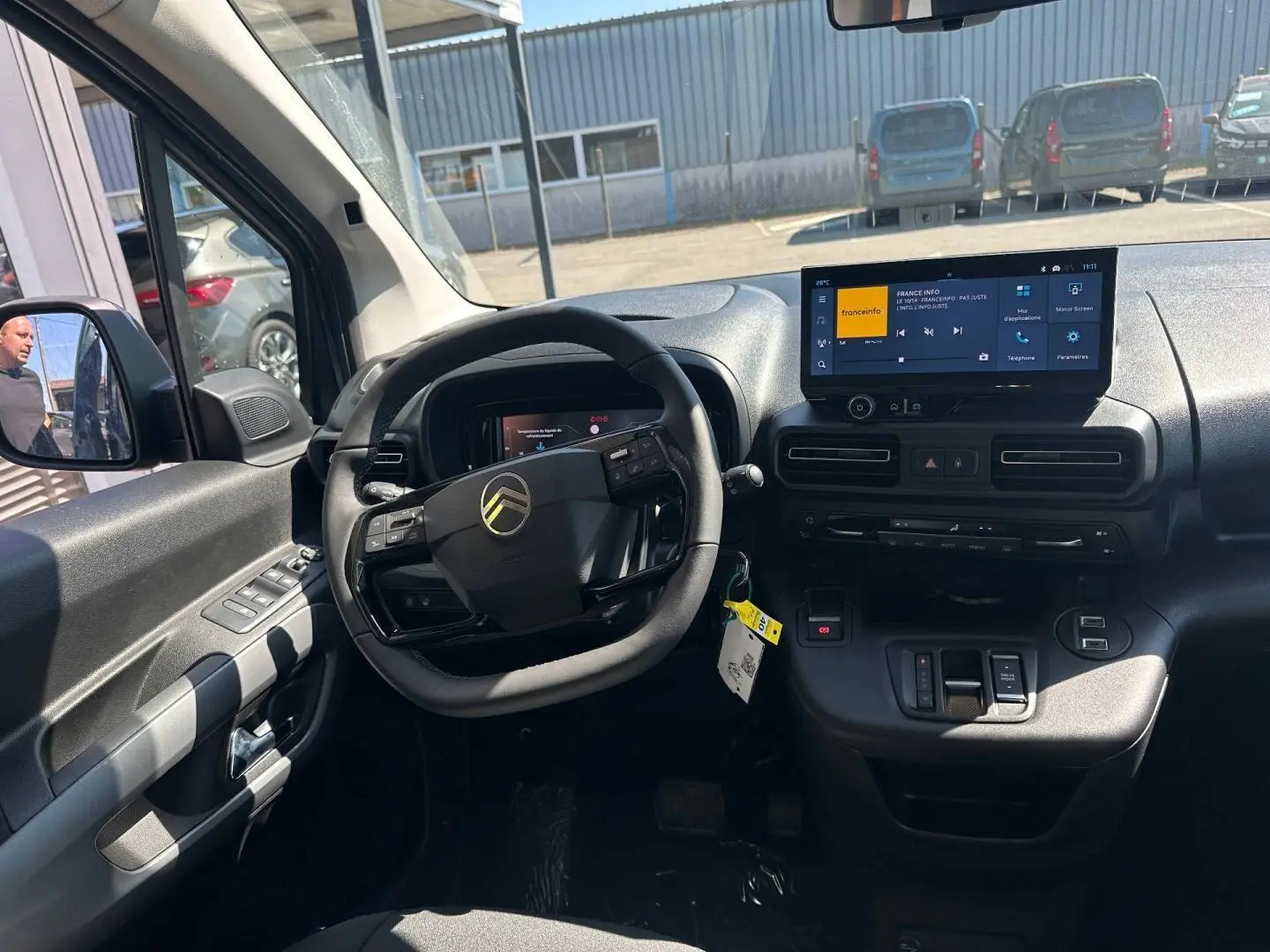 Intérieur du Citroën Berlingo 2026 en Kiama Blue, vue du poste de conduite avec volant multifonction et écran tactile central.