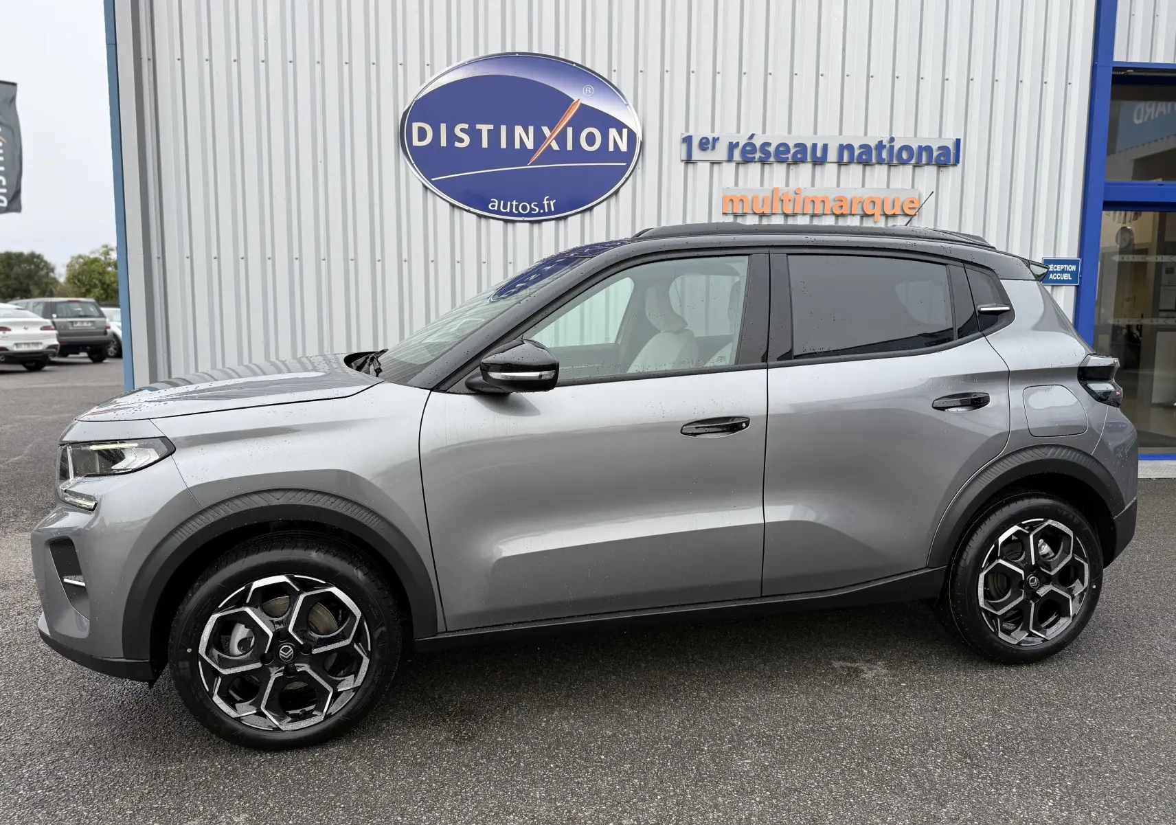 Vue de profil côté gauche d'une Citroën C3 hybride gris Mercury avec toit noir et jantes bi-ton 17 pouces.