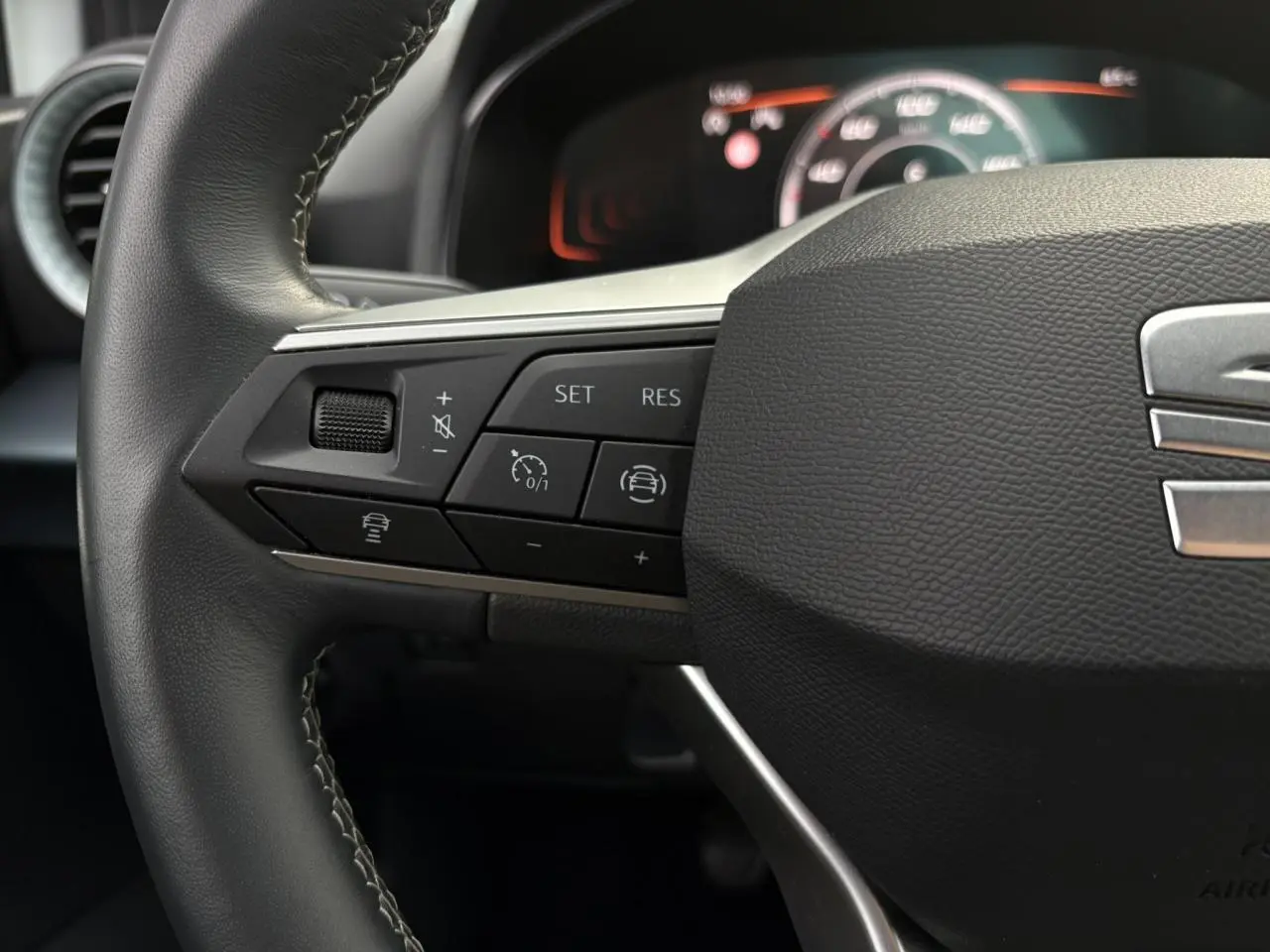 Gros plan sur le volant cuir multifonction de la SEAT Arona avec commandes de régulateur de vitesse et assistance au maintien de voie.
