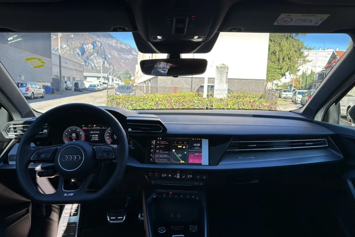 Intérieur de l'Audi A3 2025 TFSI 150 Hybrid S-Line, vue frontale du tableau de bord et volant cuir noir.