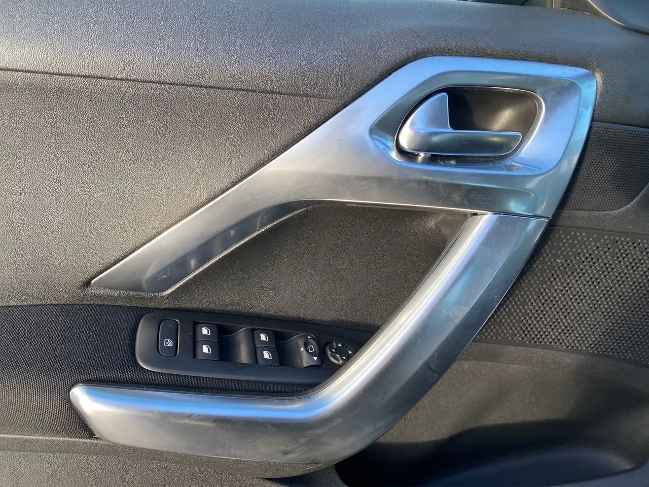 Détail de la poignée intérieure côté gauche gris métallisé avec commandes de vitres du Peugeot 2008 2019.