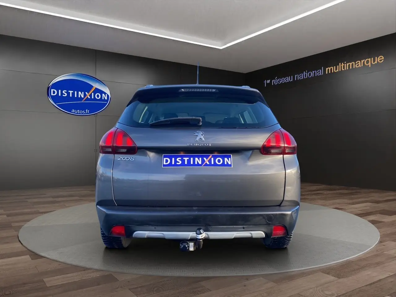 Vue arrière d'un Peugeot 2008 gris platinium 2019 avec attelage visible en showroom.