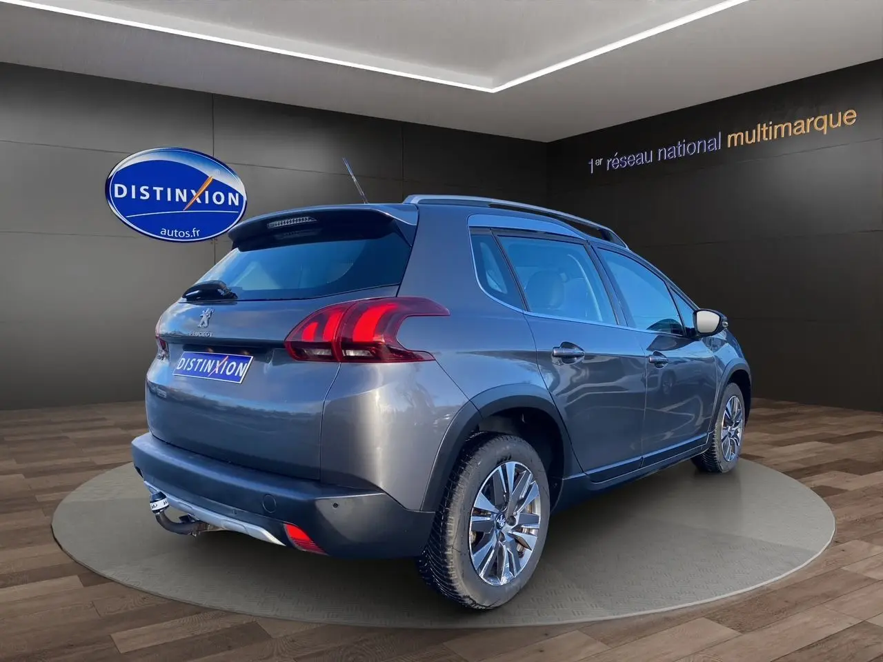 Vue 3/4 arrière droite d’un Peugeot 2008 gris platinium avec feux arrière LED et jantes alliage en showroom.