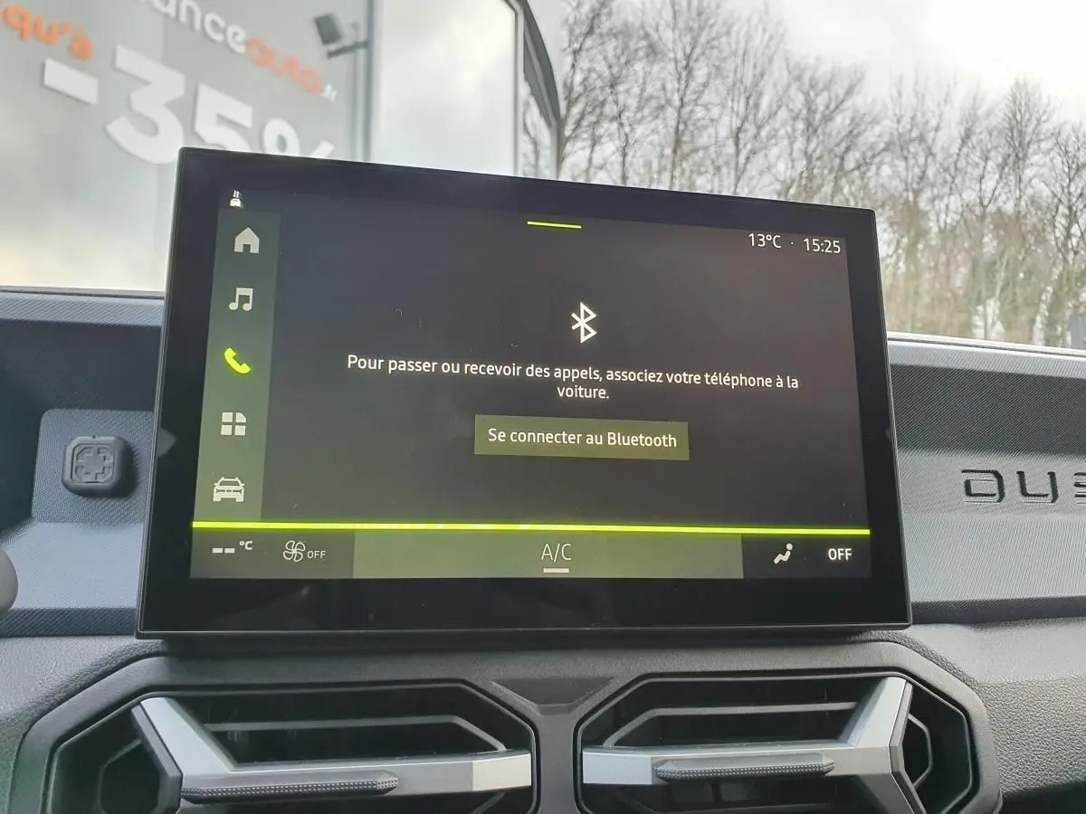 Écran tactile central du Dacia Duster 2025 affichant la connexion Bluetooth, avec tableau de bord gris et logo Duster visible.