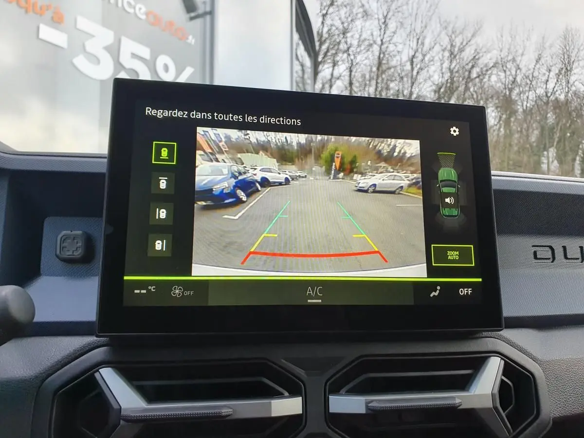 Écran central du tableau de bord du Dacia Duster blanc glacier 2025 montrant la caméra de recul en fonctionnement.