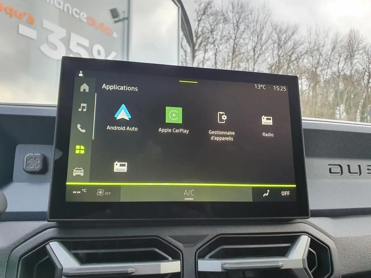 Vue intérieure du tableau de bord du Dacia Duster blanc glacier 2025, avec écran tactile Media Nav Live allumé.