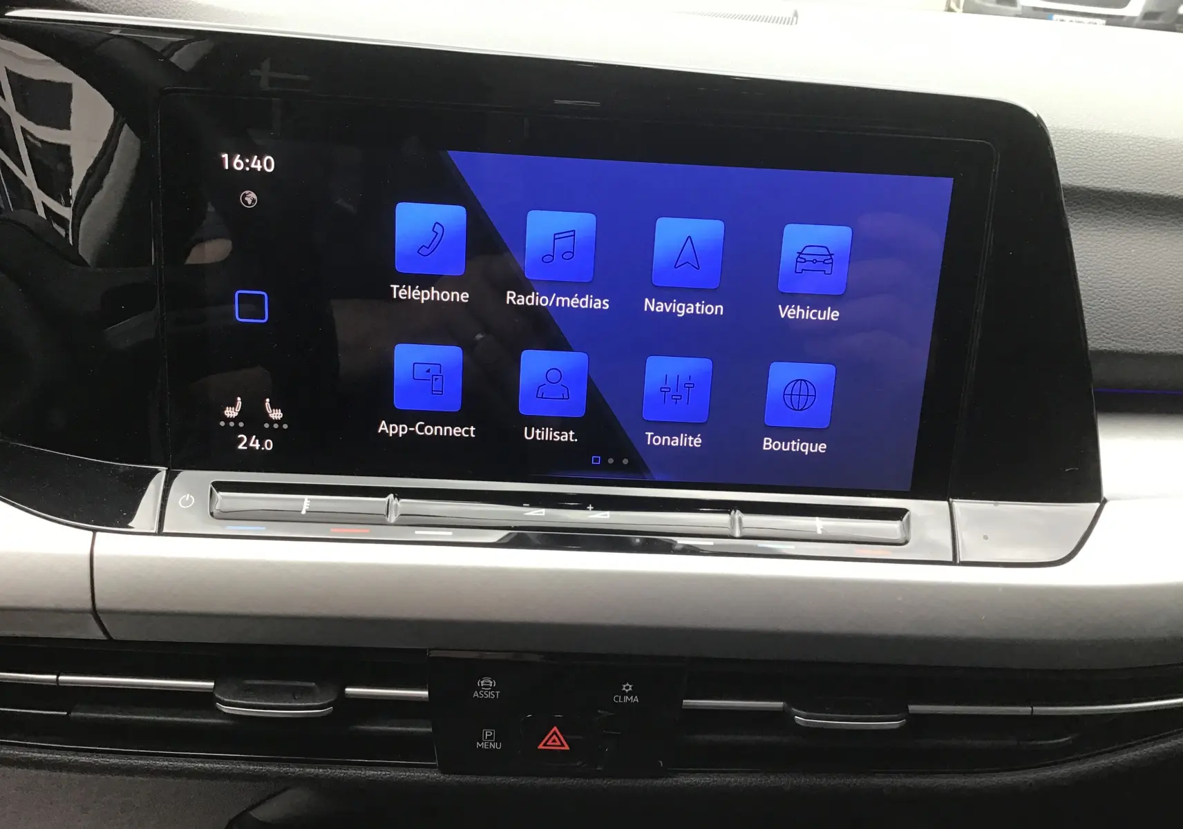 Écran tactile central bleu affichant les options multimédias et navigation dans l’habitacle d’une Volkswagen Golf gris reflex.