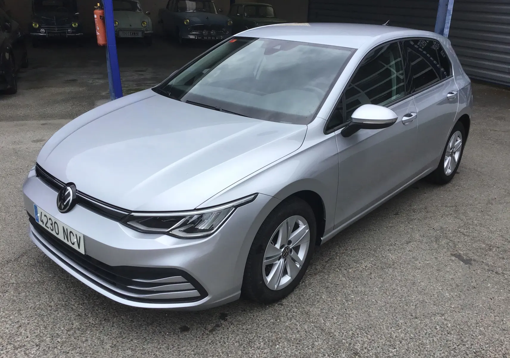 Volkswagen Golf VIII gris reflex vue 3/4 avant droit, avec jantes alliage 16 pouces et calandre moderne.