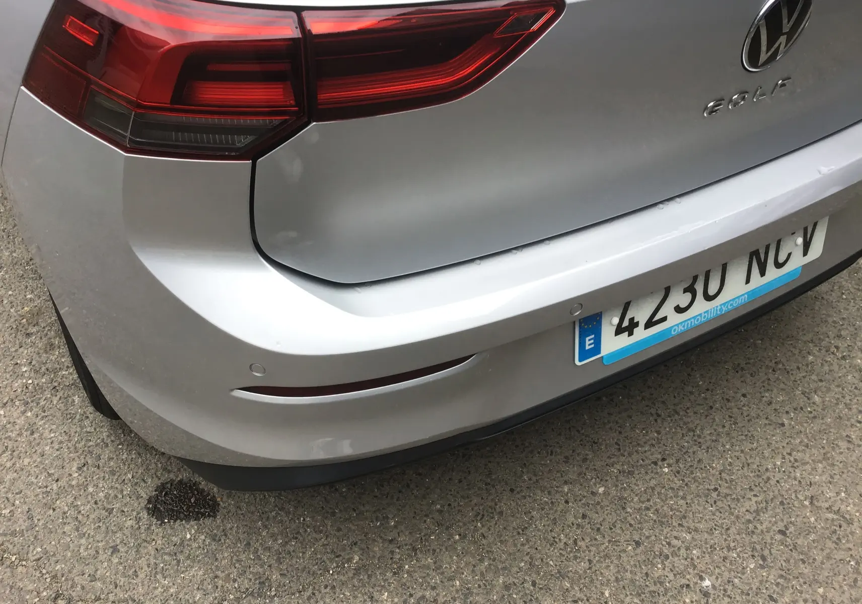 Vue arrière droite d'une Volkswagen Golf VIII gris reflex, avec feux arrière allongés et plaque d'immatriculation espagnole.