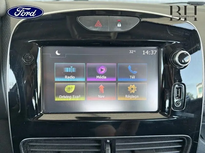 Tableau de bord noir avec écran tactile multifonction affichant radio, média, téléphone et navigation.