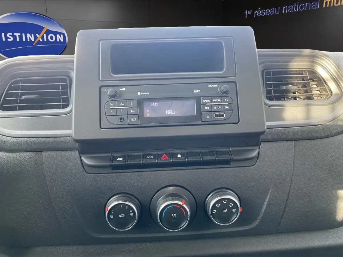 Tableau de bord du Renault Master 2024 avec radio Bluetooth, commandes climatisation et aérateurs noirs.