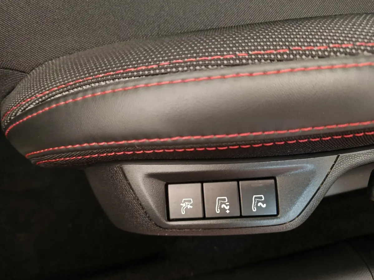 Gros plan sur les commandes de réglage des sièges en cuir noir avec surpiqûres rouges d'une Peugeot 308 GT Line 2016.