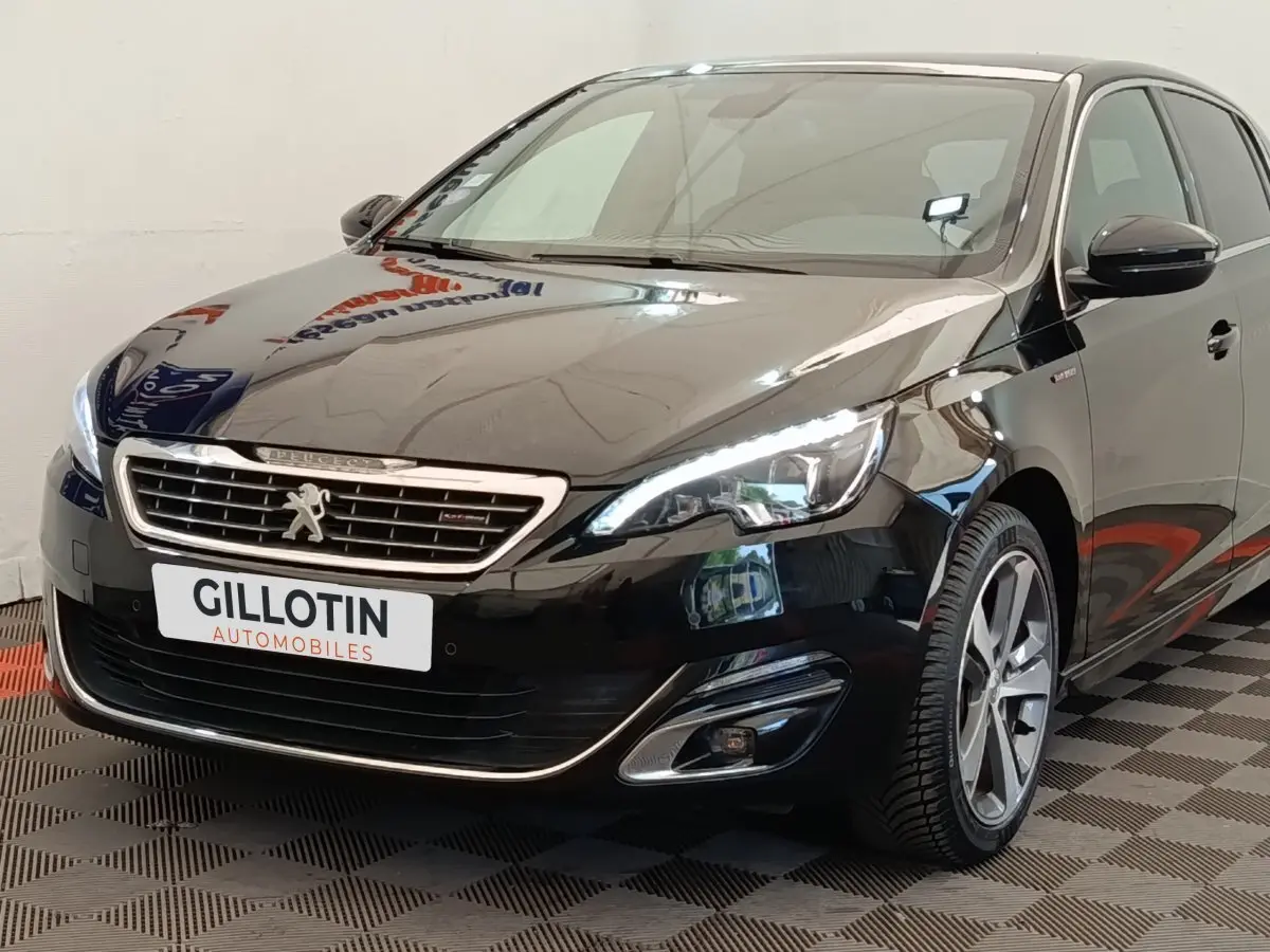 Vue 3/4 avant droite d'une Peugeot 308 noire GT Line avec phares LED et jantes alliage distinctives.