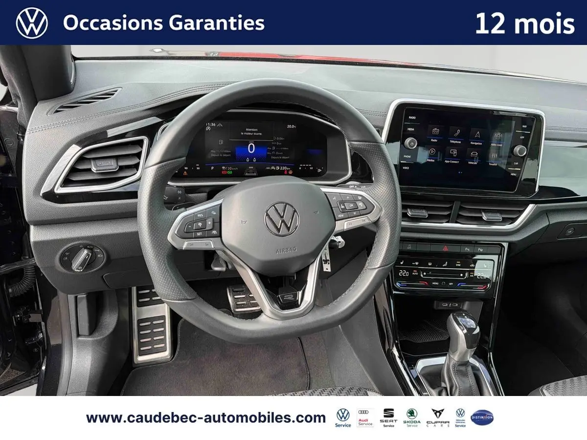 Vue intérieure centrée sur le volant cuir multifonction et tableau de bord numérique du Volkswagen T-Roc Cabriolet noir.