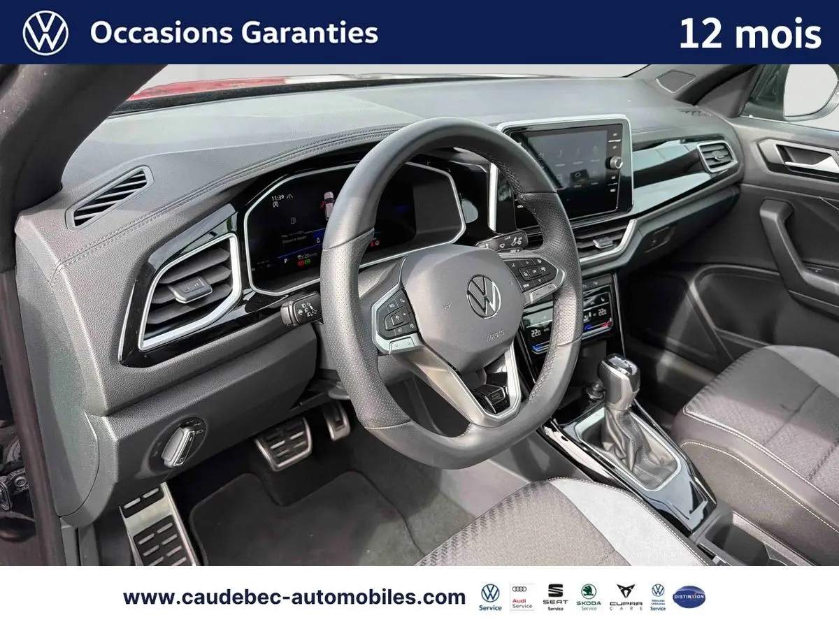 Intérieur avant droit du Volkswagen T-Roc Cabriolet noir, volant cuir multifonction et écran tactile central visible.