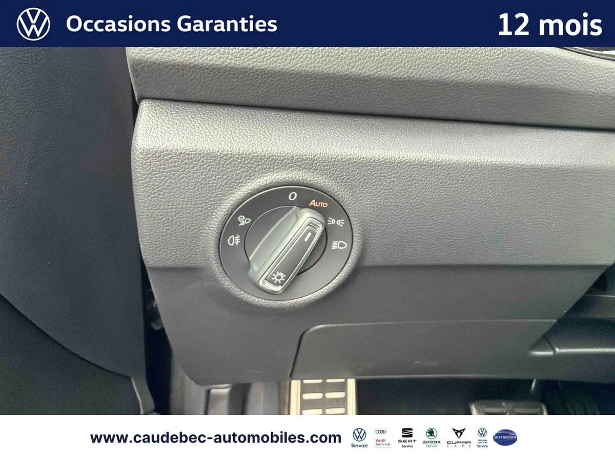 Gros plan sur le bouton de commande des phares dans l'habitacle du Volkswagen T-Roc Cabriolet noir, côté conducteur.