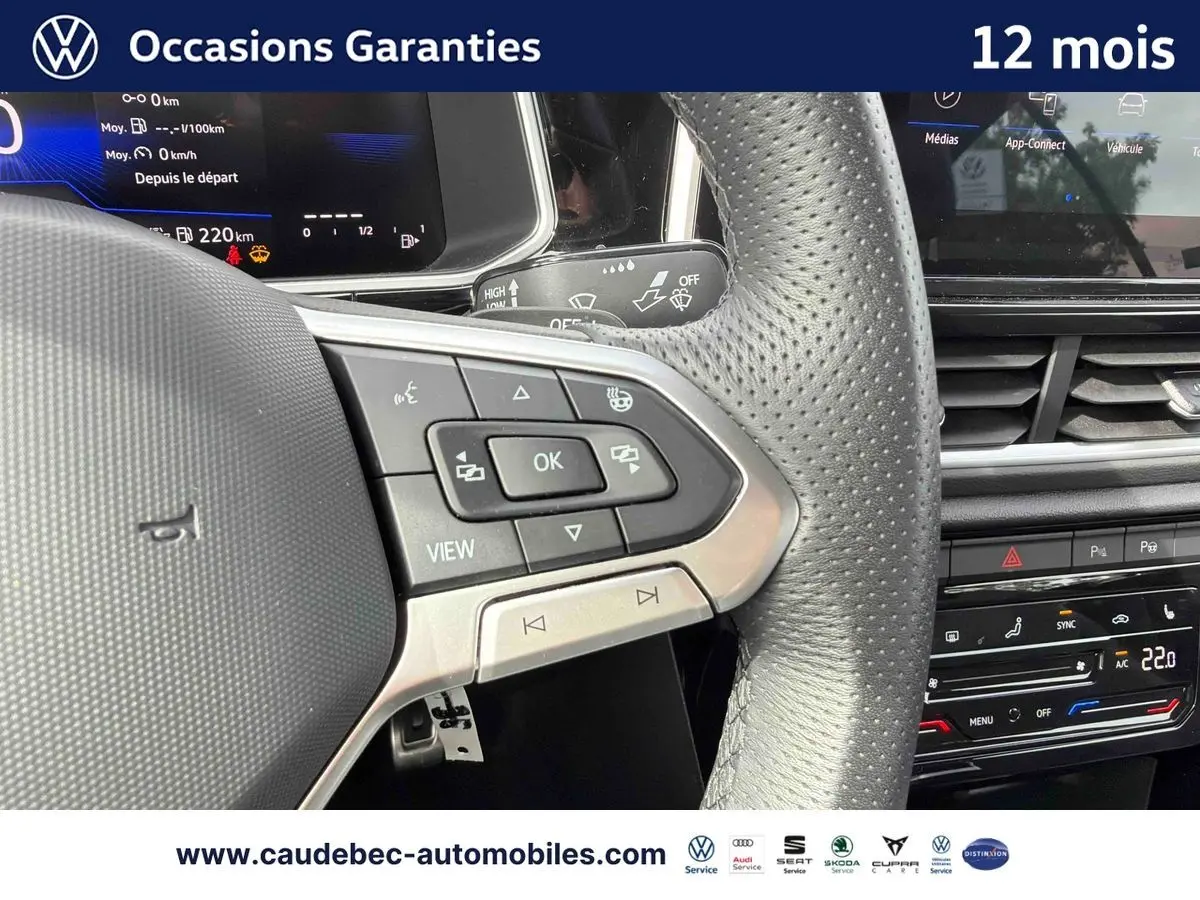 Vue rapprochée du volant multifonction en cuir perforé du Volkswagen T-Roc Cabriolet noir avec tableau de bord digital.