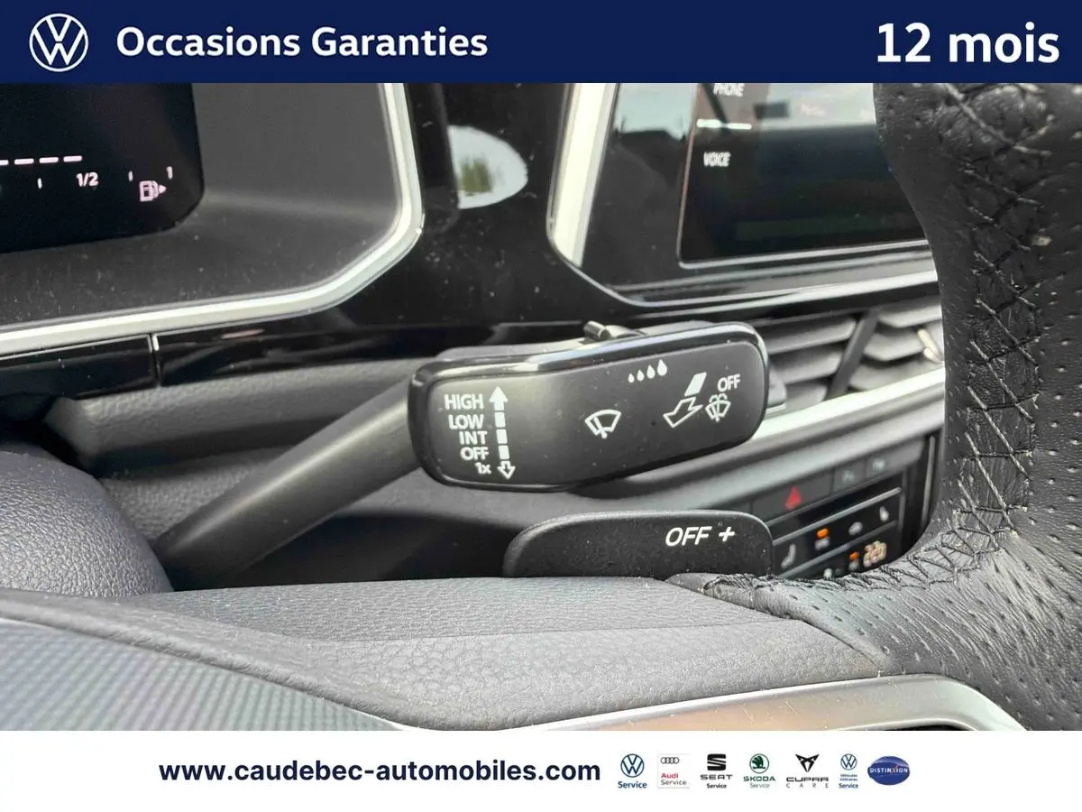 Gros plan sur la manette d'essuie-glace et le volant en cuir perforé du Volkswagen T-Roc Cabriolet noir.