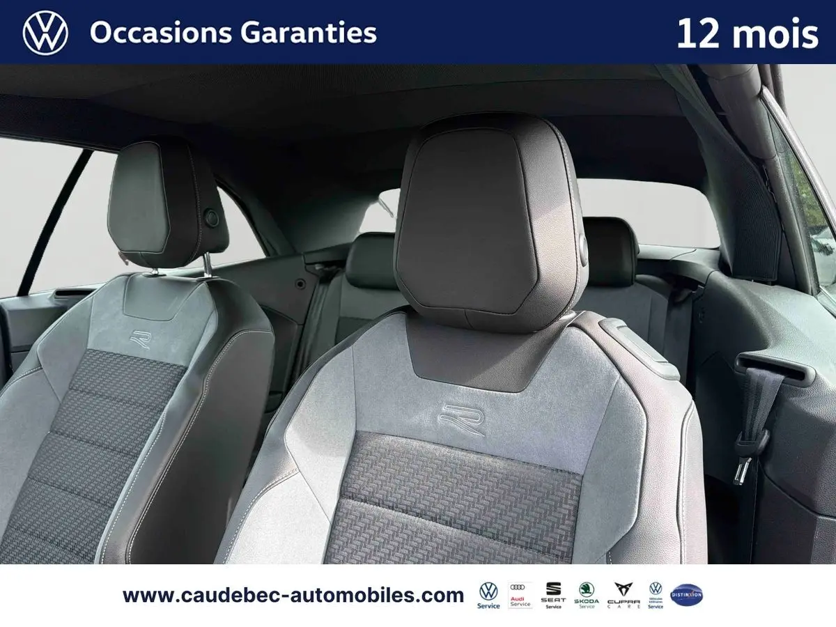 Vue intérieure rapprochée des sièges avant gris avec logo R-Line du Volkswagen T-Roc Cabriolet 2025.