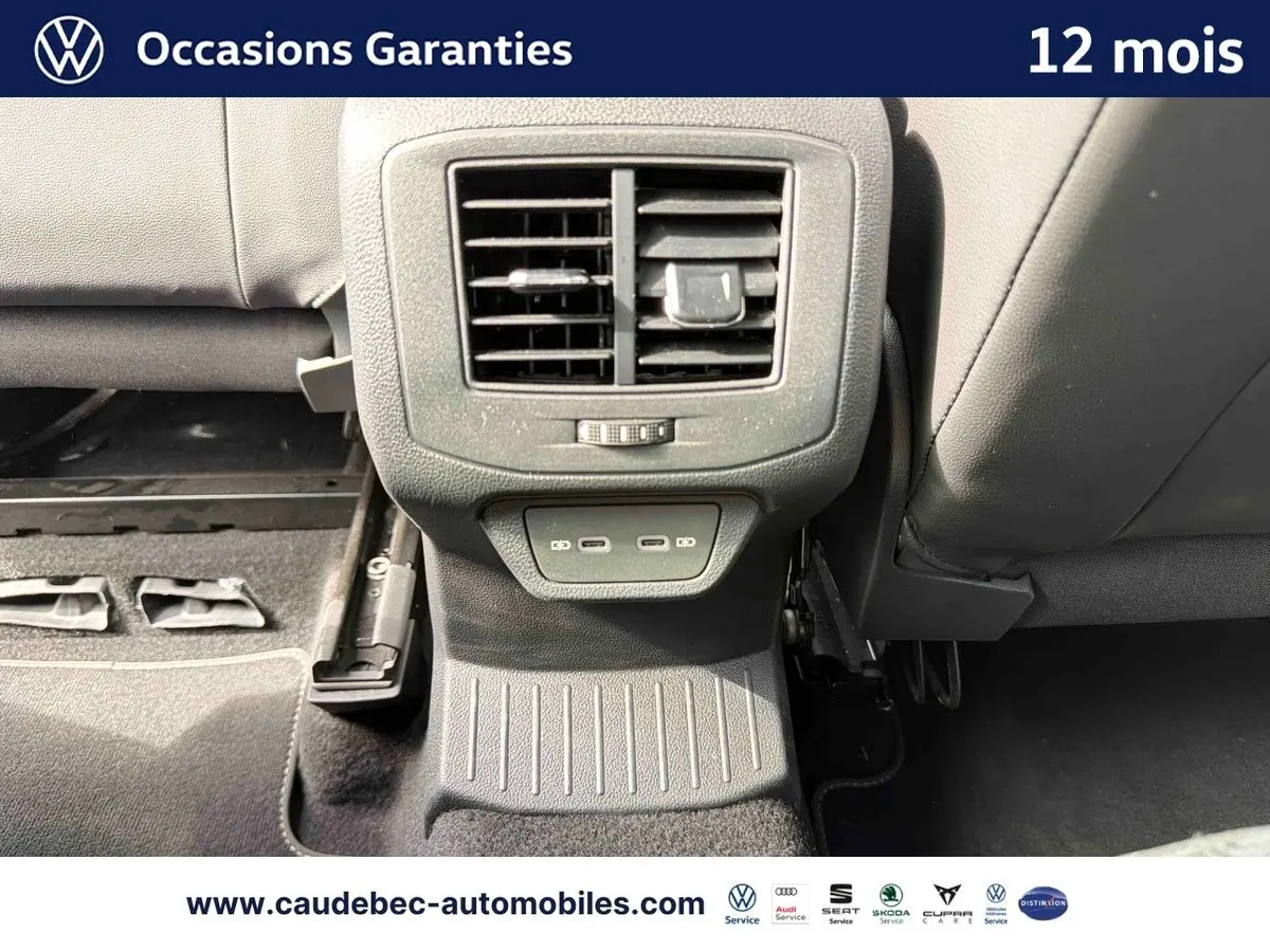 Vue rapprochée de la console arrière du Volkswagen T-Roc Cabriolet noire avec prises USB et sortie d’air centrale.