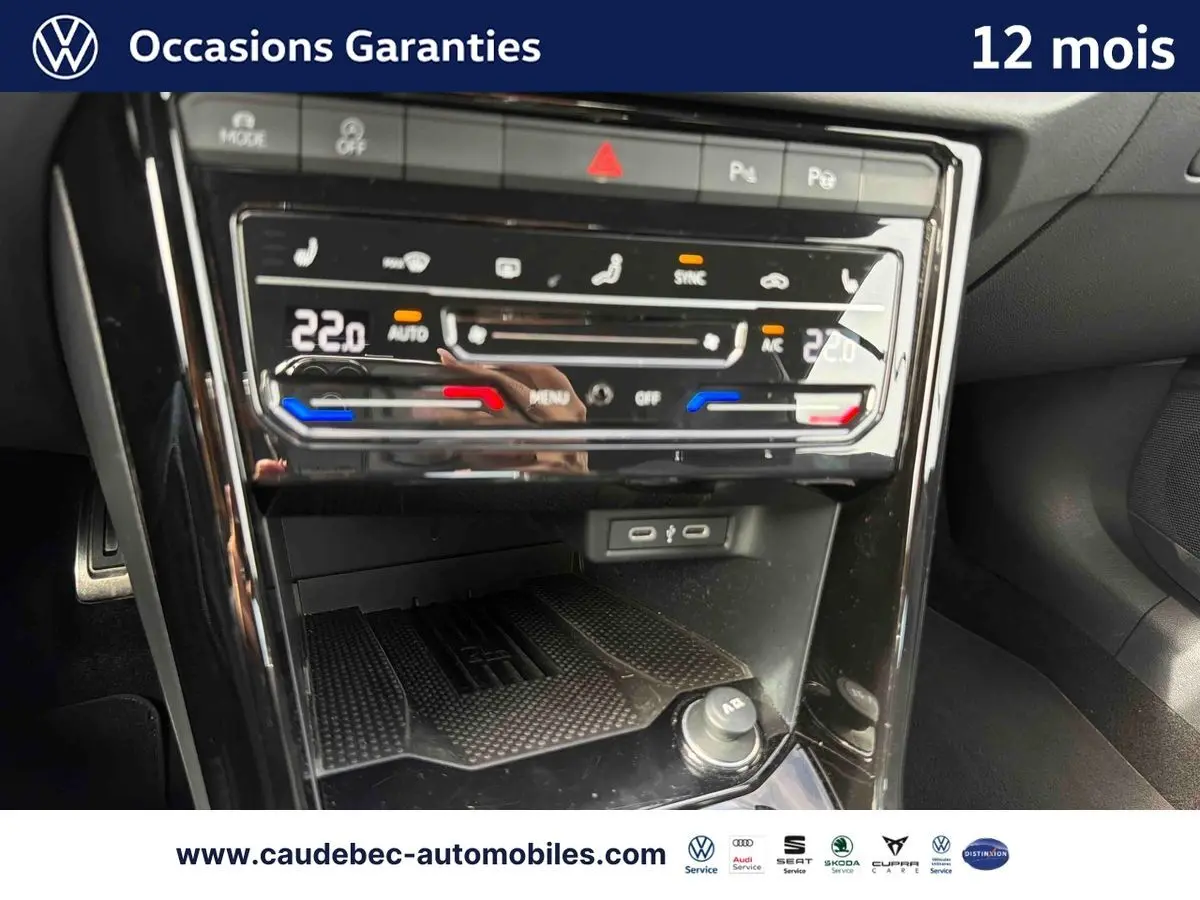 Gros plan sur la console centrale tactile du Volkswagen T-Roc Cabriolet noire, affichant la climatisation bi-zone à 22°C.