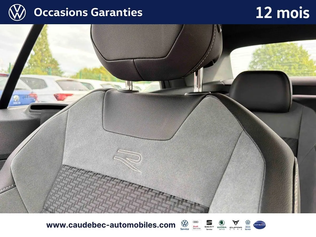 Gros plan sur le siège avant avec logo R-Line en tissu gris et cuir noir du Volkswagen T-Roc Cabriolet noir.