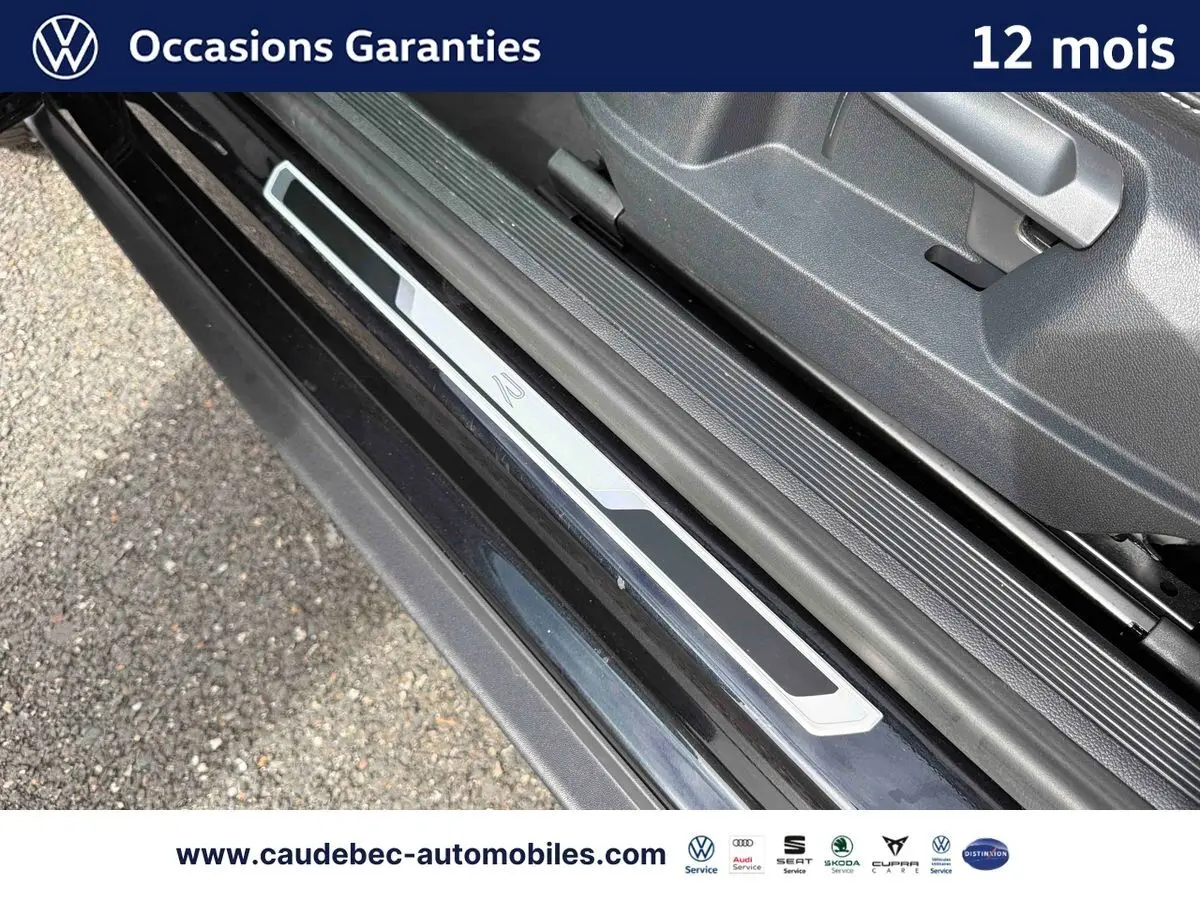 Gros plan sur la plaque de seuil de porte avec logo R-Line du Volkswagen T-Roc Cabriolet noir, côté gauche.