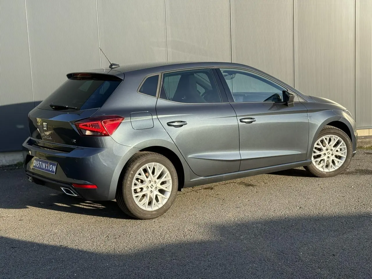 SEAT Ibiza TSI 115 FR gris magnétique vue 3/4 arrière côté droit avec jantes alliage et vitres surteintées.