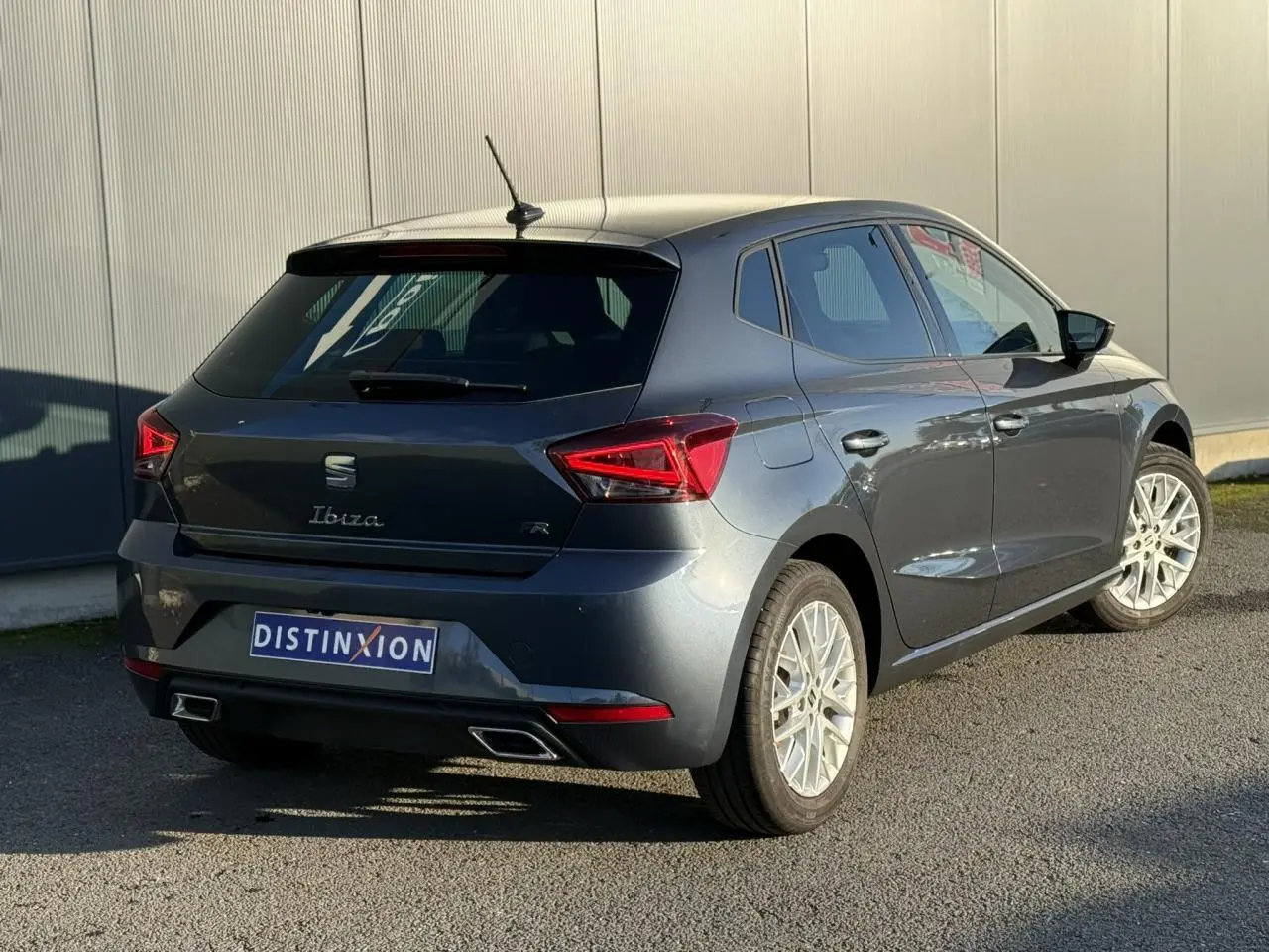 SEAT Ibiza TSI 115 FR gris magnétique vue 3/4 arrière droit avec feux LED et double sortie d’échappement.