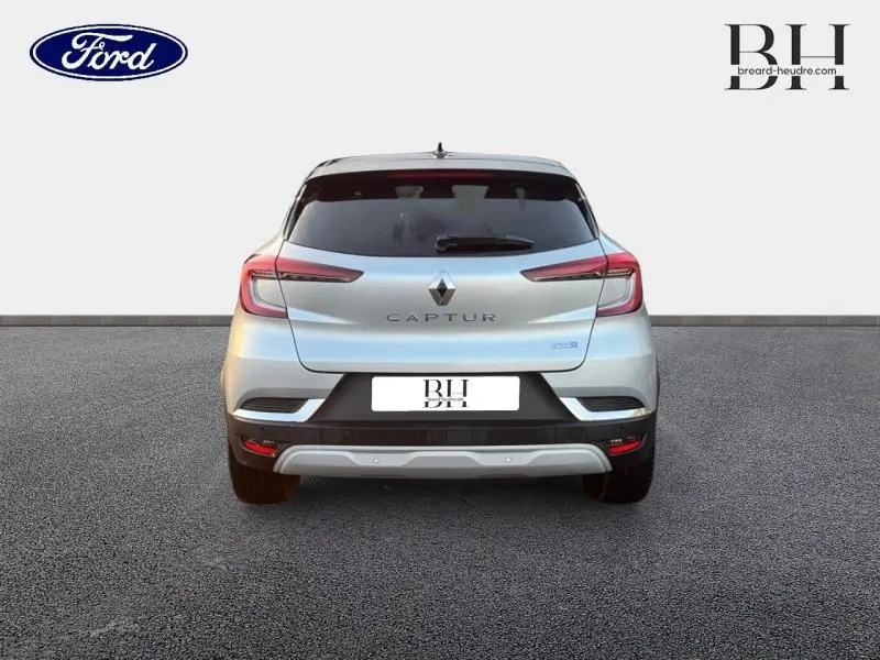 Vue arrière d'un Renault Captur gris Highland avec toit noir, feux arrière LED et sortie d'échappement chromée.